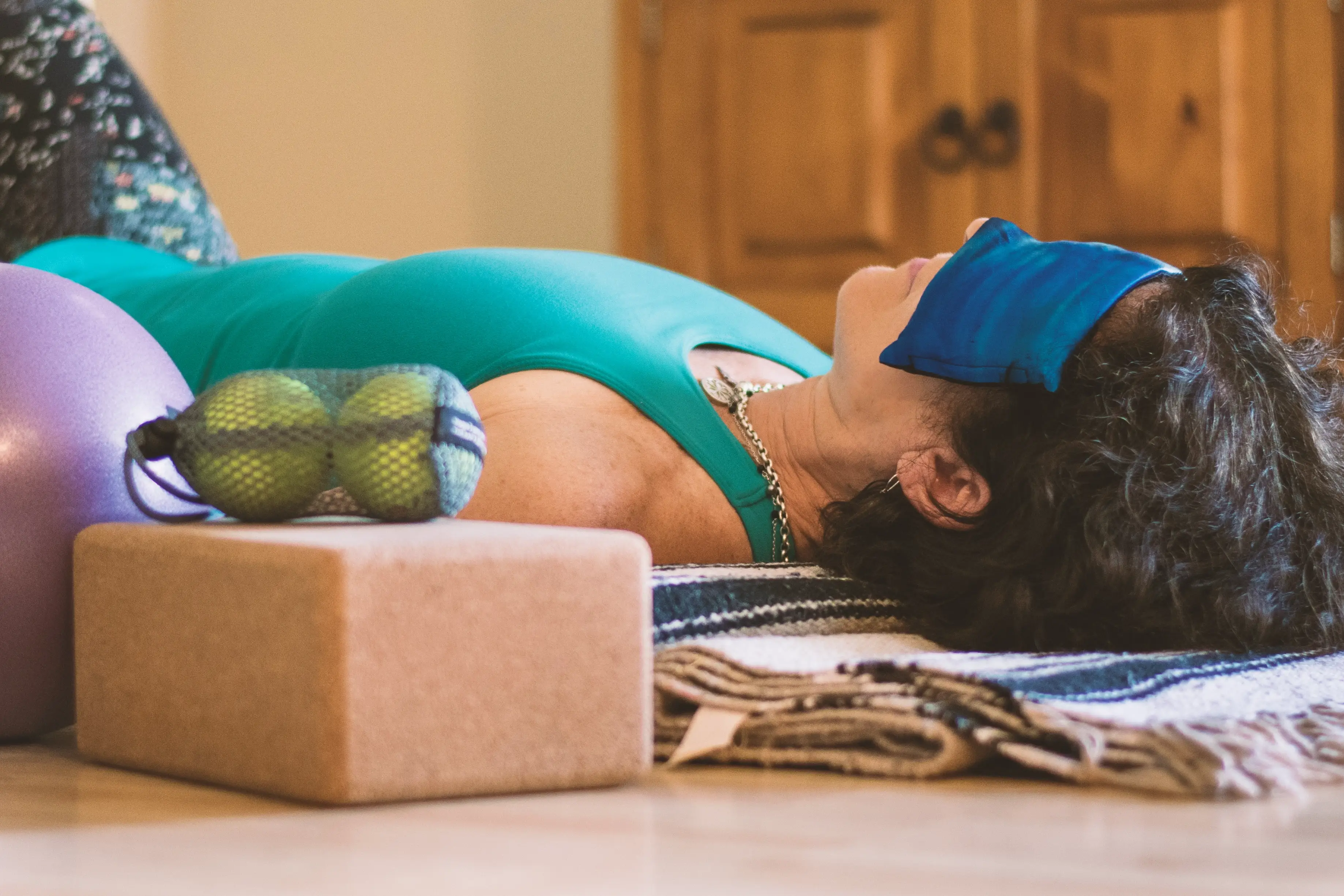 Photo: Woman in NSDR position, lying on back with sandbag over eyes in demi-corpse position, or legs bent and feet on the ground 